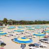 Spiaggia con lettini e ombrelloni blu e gialli.