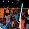 Persone ballano con palloncini colorati in una festa.