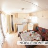 Interno di casa mobile con cucina e tavolo apparecchiato.