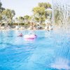 Piscina con cascata e persone che nuotano.