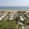 Casette vicine a una spiaggia sabbiosa e mare calmo.