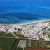 Vista aerea di una città costiera con spiagge e mare blu.