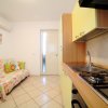 Cucina moderna con mobili gialli, divano colorato e condizionatore d'aria.