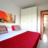 Camera da letto con copriletto rosso e quadri colorati.