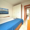 Una camera da letto con letto matrimoniale, copriletto blu e armadio bianco.