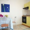 Cucina gialla con tavolino, sedie e quadro floreale blu.