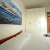Camera da letto con letto matrimoniale, un armadio bianco e un quadro del mare appeso sopra.